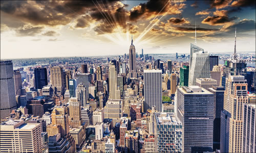 Aerial view of Manhattan showing hundreds of office buildings under a sunny sky